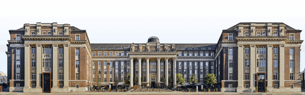 Panoramafotografie der historischen Fassade des Luxushotels The Wellem in Düsseldorf mit monumentalen Säulen, symmetrischer Architektur und klassizistischen Details bei klarem Tageslicht.